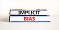 Implicit bias symbol. Concept words Implicit bias on books. Beautiful white table white background. Business psychology implicit