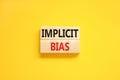 Implicit bias symbol. Concept words Implicit bias on wooden block. Beautiful yellow table yellow background. Business psychology