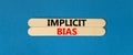 Implicit bias symbol. Concept words Implicit bias on wooden sticks. Beautiful blue table blue background. Business psychology