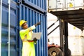 Import and Export concept. Foreman using laptop computer in the port of loading goods. Businessman with safety equipment working Royalty Free Stock Photo