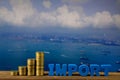 IMPORT text and stack of coin on wood table over seascape and ca Royalty Free Stock Photo
