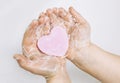 Importance of personal hygiene care. Flat lay view of child washing dirty hands with pink heart shape soap bar, lot of foam. Copy