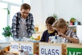 Ginger teacher in clear glasses explaining recycling bases