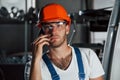 Important conversation. Portrait of engineer in metallurgical factory in protective helmet and eyewear