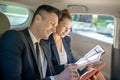 Man with tablet and woman discussing business in car. Royalty Free Stock Photo