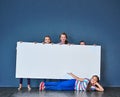 An important message brought to you by the kids. Studio shot of a diverse group of kids standing behind a large blank Royalty Free Stock Photo