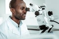 Handsome dentist in special white uniform looking in oral cavity Royalty Free Stock Photo