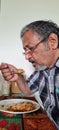 Senior Hungry Indian man eating simple diet breakfast