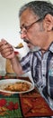 Senior Hungry Indian man eating simple diet breakfast