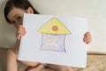 It is important to stay home during a pandemic. Coronovirus World Quarantine. Little girl holding a drawing in her hands Royalty Free Stock Photo
