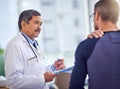 It is important that you take it easy from now on. a confident mature male doctor doing a checkup on a patient while Royalty Free Stock Photo