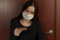 Imposing a fine for leaving the house with a coronavirus. Sad young woman in a medical mask holds in her hands payment in euros Royalty Free Stock Photo