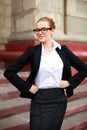 Imposing girl student in business suit in front of university