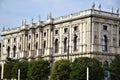 Imposing and historic palace, with columns on the facade and sides and many statues on the cornice, seen from the garden, in Vienn