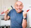 imposing man in prime of life holds in teeth of screws and holding hammer