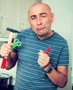 Imposing man in prime of life holds in teeth of screws and holding hammer