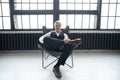 Imposing mature man in elegant suit sitting on a leather chair in a modern luxurious interior. Fashion. Business Royalty Free Stock Photo