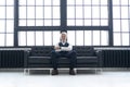 Imposing mature man in elegant suit sitting on a leather sofa in a modern luxurious interior. Fashion. Business Royalty Free Stock Photo