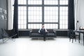 Imposing mature man in elegant suit sitting on a leather sofa in a modern luxurious interior. Fashion. Business