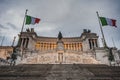 Imposing monument Altare della Patria or Vittoriano with fluttering Italian flags shows renaissance architecture. Fatherland Altar