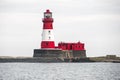 a large white and red lighthouse with a tower on top of it