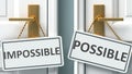 Impossible or possible as a choice in life - pictured as words Impossible, possible on doors to show that Impossible and possible