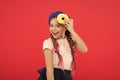 Impossible to resist fresh made donut. Girl hold glazed cute donut in hand red background. Kid playful girl ready to eat