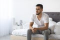 Impotence Concept. Upset Pensive Young Arab Man Sitting On Bed At Home