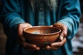 Impoverished elderly hands hold empty bowl, selective focus reveals hungers impact