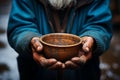 Impoverished elderly hands hold empty bowl, selective focus reveals hungers impact