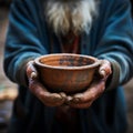Impoverished elderly hands hold empty bowl, selective focus reveals hungers impact
