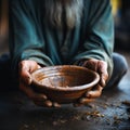 Impoverished hands cradle empty bowl, selective focus underlining hungers reality