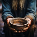 Impoverished hands cradle empty bowl, selective focus underlining hungers reality