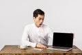 Impressed, shocked and astonished young chinese man in office, manager sitting table looking laptop screen, showing Royalty Free Stock Photo