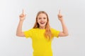 Impressed teen girl pointing fingers up and looking amazed, smiling with joy and excitement, standing over white background Royalty Free Stock Photo