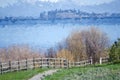 Impressionistic Style Artwork of a Wooden Fence at the Edge of a Springtime Lake