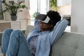 Impressions smiling African American young woman using VR headset immersing herself in metaverse Royalty Free Stock Photo