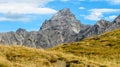 Impressive alpine peak with yellow grass