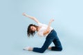 Impressive contemporary dancer poses in front of blue studio background