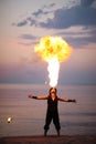 Impressive fire-breathing on the beach at sunset Royalty Free Stock Photo