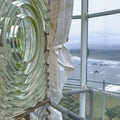 Lens of Cape Blanco Lighthouse with foggy coastline below, Oregon