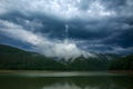 Impressive landscape of green coniferous mountains above lake against the background of stormy gray clouds, rainy weather, Ukraine Royalty Free Stock Photo