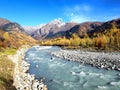 Vast wilderness landscape in Georgia during a trekking in the remote svaneti region with a glacial river and autumn mountains