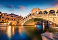 Impressive sunset on famous Canal Grande. Colorful spring view of Rialto Bridge. Picturesque evening cityscape of Venice, Italy,