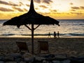 Sunset with a traditional straw beach umbrella and two deckchairs facing the peaceful Indian Ocean coast, Anakao, Madag