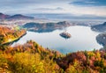 Impressive view of church of Assumption of Maria on the Bled lake. Foggy autumn landscape in Julian Alps, Slovenia, Europe. Beauty