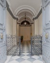 An impressive vintage apartment building entrance with heavy metallic open doors to the hallway.