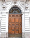 An impressive vintage house entrance with a natural wood arched door.