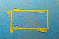 Imprint of a yellow irregular frame on a bright blue powder. Copy space. Abstract background. Top view.