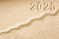 Imprints of numbers 2025 new year on a golden sand waves